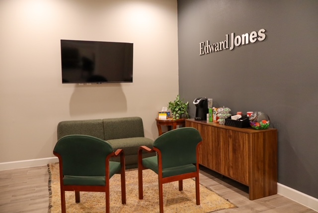 A clean empty waiting area of an Edwards Jones office building with chairs and a TV.